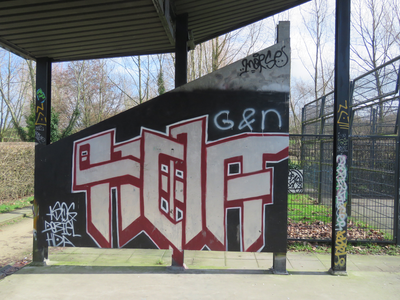 833346 Afbeelding van graffiti met een gestileerde tekst, op een wand van de voetbalkooi in het Griftpark te Utrecht.